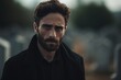 © Rudsaphon - Portrait of a sad and depressed man in a black coat on the background of a cemetery.Funeral Concept