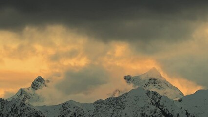 Wall Mural - Alpine landscape with moving clouds at sunrise