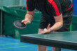 Table tennis player serving in a table tennis championship match