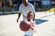 © Davor - Adorable little girl playing basketball with father on outdoor court