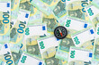 © George - Top left view over a little black compass over many euro banknotes, 100 euro money bills, navigation in the world of finance concept