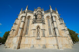 Fototapeta  - Klasztor Batalha, Portugalia. Monumentalne, sakralne dzieło architektoniczne. Perspektywa, linie zbieżne, jaste, piaskowe, strzeliste wieżyczki. na tle granatowego nieba