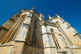 Fototapeta  - Klasztor Batalha, Portugalia. Monumentalne, sakralne dzieło architektoniczne. Perspektywa, linie zbieżne, jaste, piaskowe, strzeliste wieżyczki. na tle granatowego nieba