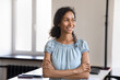 © fizkes - Happy pretty young African American business leader woman in casual portrait. Thoughtful female manager, employee, entrepreneur standing in office, looking away with arms folded, dreaming, thinking