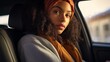 Junge Frau mit dunklen Locken und orangem Kopftuch sitzt im Auto 
