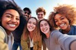 Young individuals of different races smiling together in front of the camera - Joyful group of friends enjoying themselves while snapping a selfie with a smart phone - A concept of a youth community