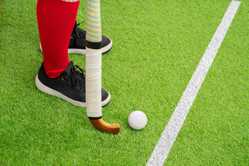 Closeup of a man field hockey player on the grass green background