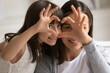 © fizkes - Portrait close up happy mother and daughter showing heart sign with fingers, looking at camera, smiling young mum and adorable cute little girl having fun, child and mom connection and unity