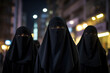 Three Middle Eastern women wearing niqab on city street