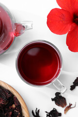 Poster - Delicious hibiscus tea and flowers on white background, flat lay