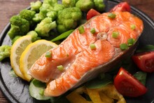 Healthy Meal. Grilled Salmon Steak, Green Onion, Lemon And Vegetables On Table, Closeup