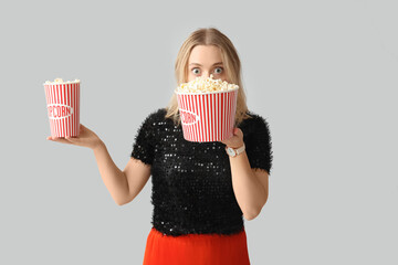 Wall Mural - Young woman with buckets of popcorn on white background