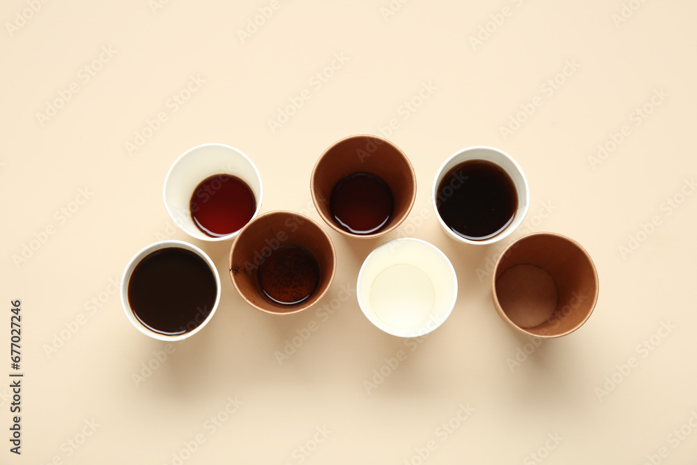 Many paper cups of hot coffee on beige background