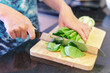 Woman hands cutting fresh green bok choy (pak choy)