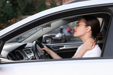 Canvas Print - Young woman suffering from neck pain in her car