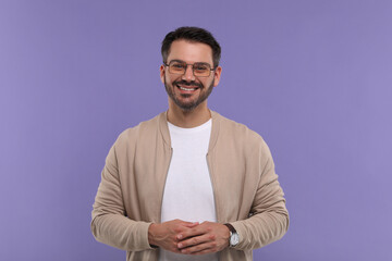 Canvas Print - Portrait of happy man in stylish glasses on violet background