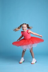 Sticker - Cute little girl in tutu skirt dancing on light blue background