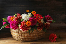Beautiful Wild Flowers And Leaves In Wicker Basket On Wooden Table
