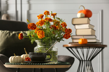 Canvas Print - Beautiful autumn flowers, cup of drink and pumpkins on coffee table indoors, space for text