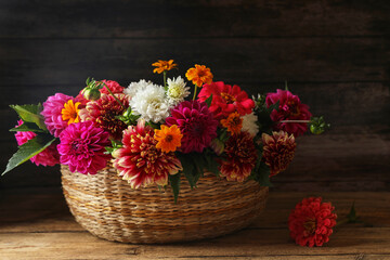 Canvas Print - Beautiful wild flowers and leaves in wicker basket on wooden table