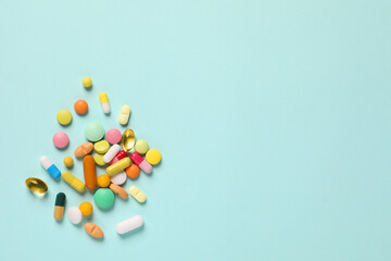 Poster - Many different pills on light blue background, flat lay. Space for text