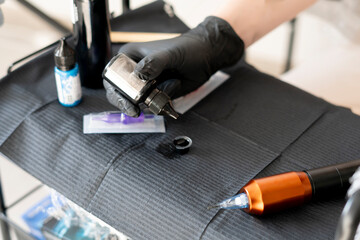 Wall Mural - a tattoo studio table with machine, needle and bottles with ink