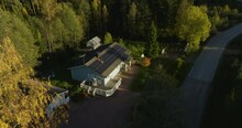 Aerial View Around A Tree, Revealing A House With Solar Cells, Fall Evening