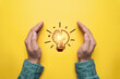 © Dilok - Two hand protect glowing lightbulb on yellow background for  prevent patent and idea of problem solving solution and creative thinking concept.