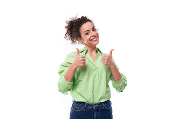 Wall Mural - charming young brunette curly woman with a ponytail hairstyle is dressed in a green shirt and jeans