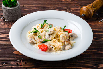 Canvas Print - Linguini pasta with chicken fillet, mushrooms, cheese, cream sauce, tomatoes and herbs, Italian food.