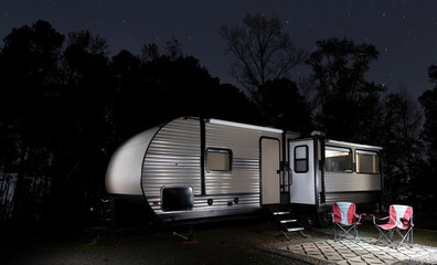 Wall Mural - stars in the sky above an rv with a forest silhouetted behind.