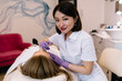 © BullRun - Positive Asian beautician doing injection in salon