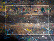 © tete_escape - White frame on wood plank top table covered in oil or acrylic color paint splatter. Abstract texture of old rustic wooden desk background of artist studio with messy colorful color painted splash.