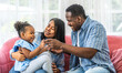 © Art_Photo - Portrait of enjoy happy love black family, play, having fun, daughter, parenthood, care, african american father and mother with little african girl child smiling moments good time at home