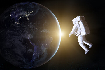 Wall Mural - astronaut in deep space looks on night earth planet. elements of this image furnished by nasa.