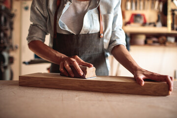 Wall Mural - Young Female Artisan Carpenter Sanding Wood in a Workshop