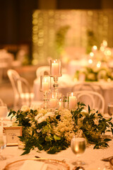 Wall Mural - Wedding table decorations with candles in a light bokeh background