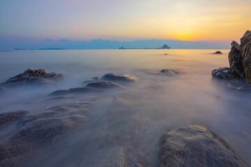 Wall Mural - Long exposure of a sunset over the rocky sea.