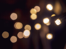 Blurred Out-of-focus Bright Lights Of A Garland On A Dark Background Close-up