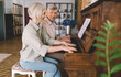 © BullRun - Happy aged gray haired couple playing piano in modern apartment