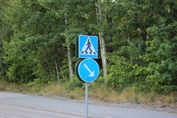 Pedestrian road sign with a direction sign on a pole