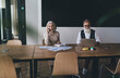 © BullRun - Elderly colleagues sitting at table and working in office