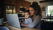 Latin woman multi-tasking working at a laptop with her young son at home. Generative AI.