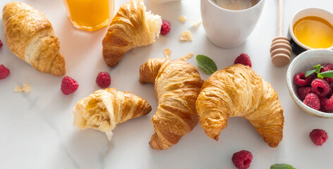 Poster - Continental breakfast with croissants, orange juice and cup of coffee on white marble background top view. Healthy breakfast eating, various morning food concept