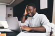 © BullRun - Smiling black man using laptop during studies