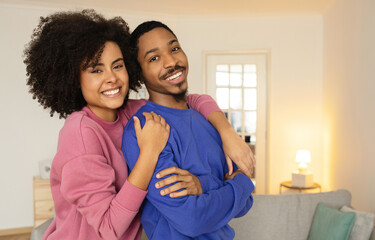 Wall Mural - African American spouses sharing warm embrace and joyful smiles indoor