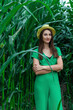 © volhavasilevich - Young pretty woman in the yellow hat among the corn plants in the corn field in summer season. Bereza, Belarus