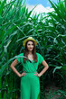 © volhavasilevich - Young pretty woman in the yellow hat among the corn plants in the corn field in summer season. Bereza, Belarus