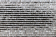 Gray Wooden Roof Tiles Background Texture. A Close Up Of Old Gray Roof Covered With Wooden Tiles Or Shingles