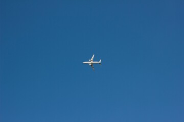 White aircraft flying in the clear blue sky